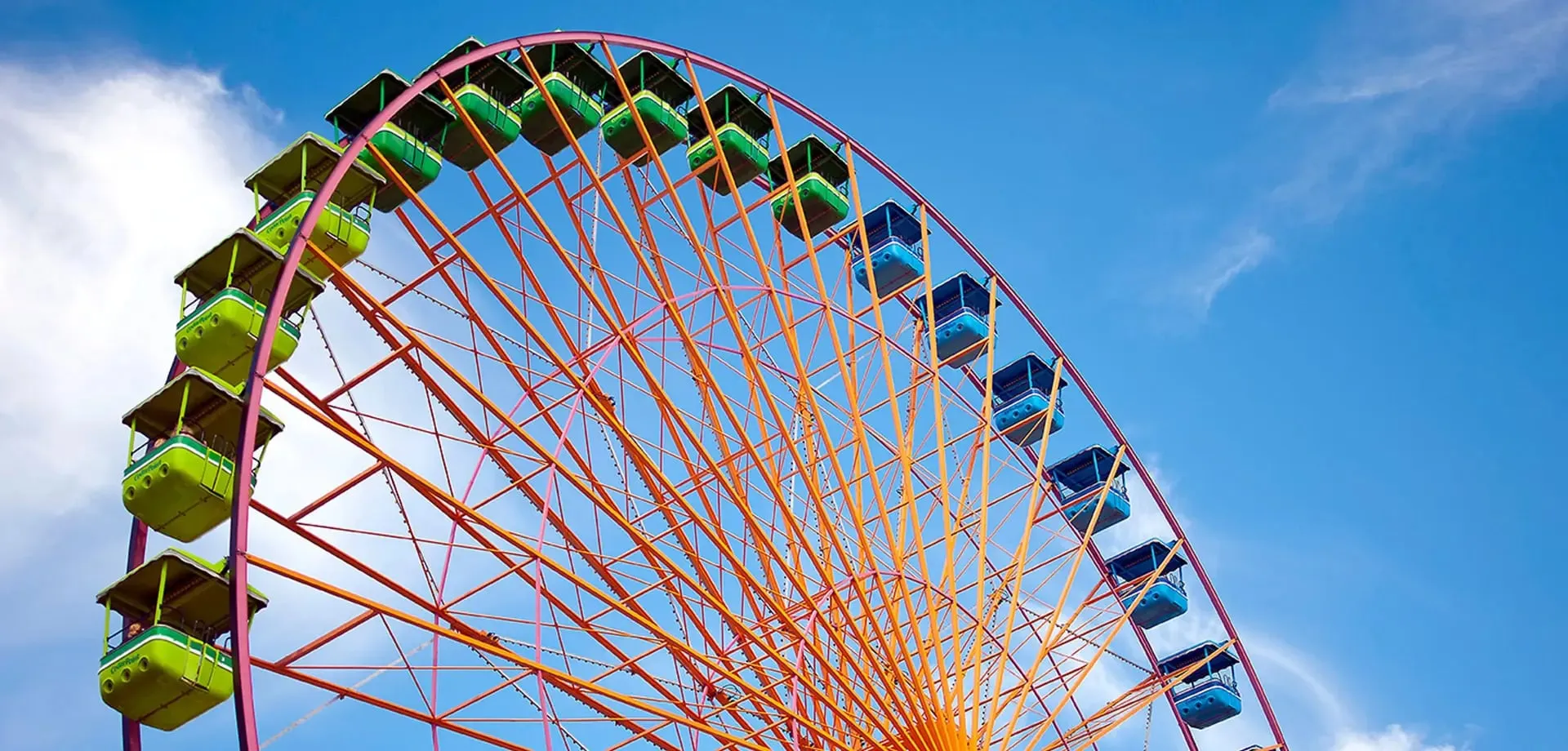 A brightly colored Ferris wheel against a clear blue sky.