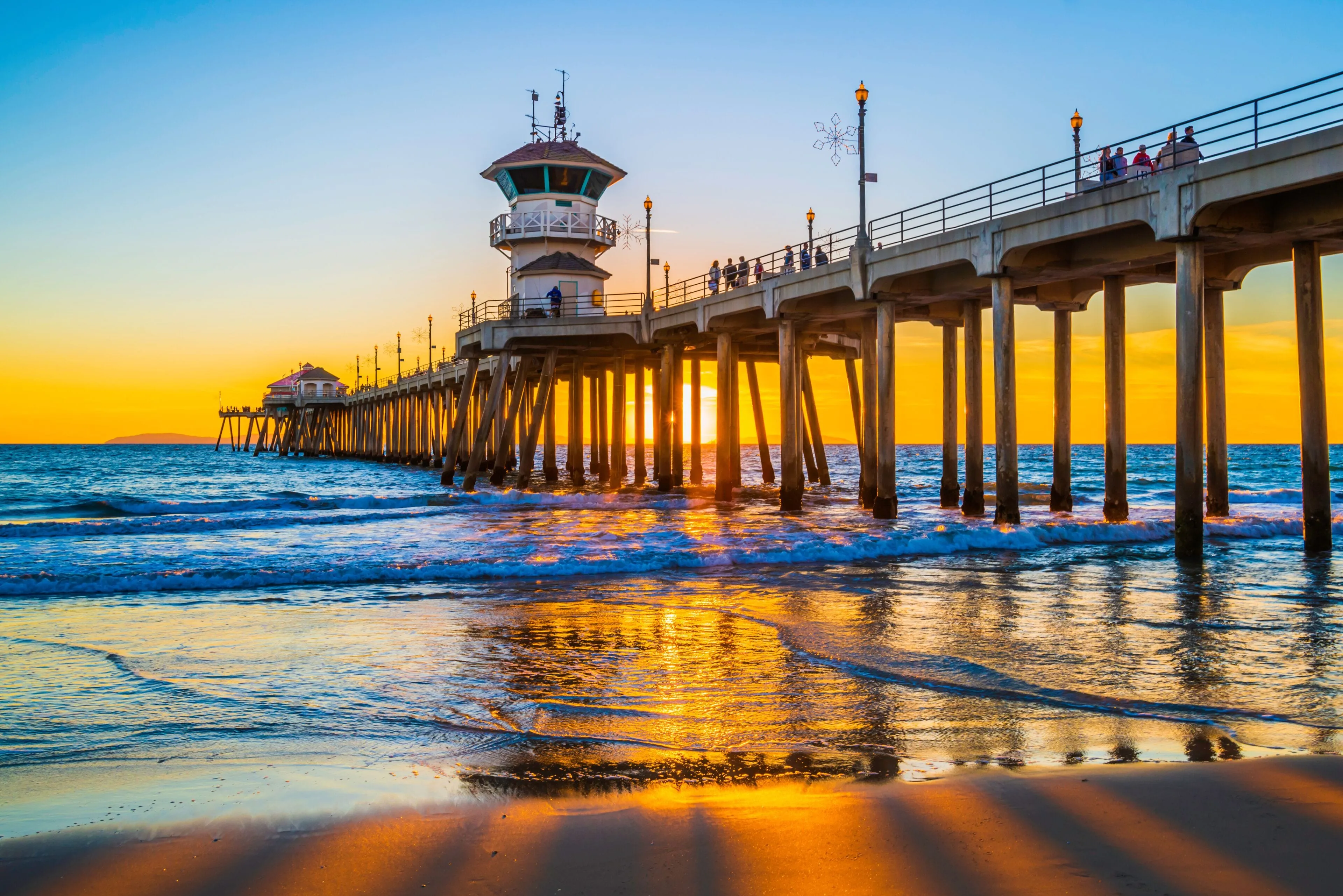 The Huntington Beach Pier at sunset with golden light reflecting off the waves — Odin Systems provides mobile surveillance and integrated video security across Orange County and the Inland Empire.