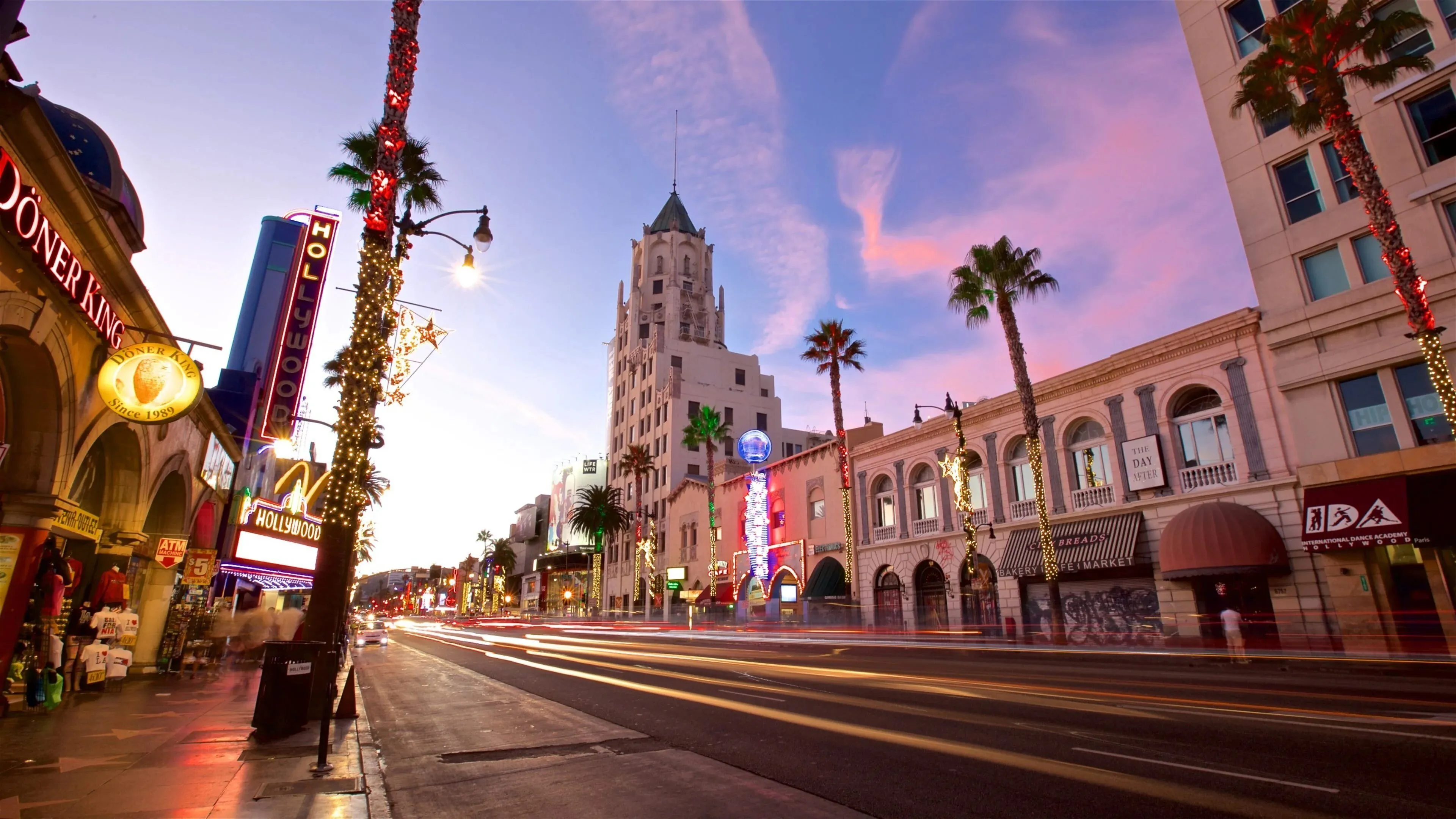 Hollywood Boulevard in Los Angeles at dusk with traffic light trails and neon signage — Odin Systems provides off-grid mobile surveillance and permanent video security across the Los Angeles region.