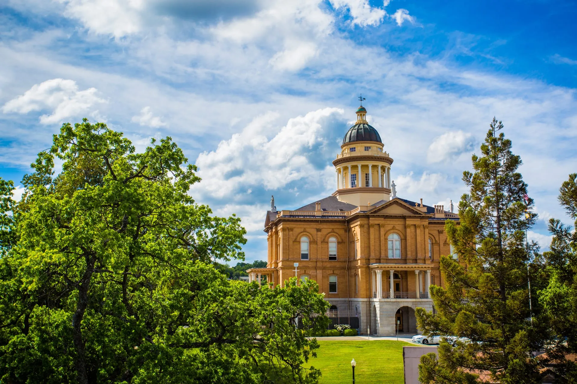 The historic Auburn, California courthouse — a domed sandstone civic building against a blue sky.